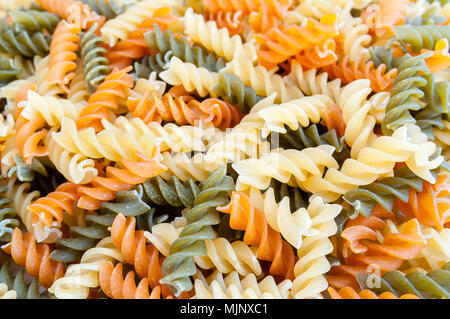 Getrocknete tricolore Fusilli Nahaufnahme Hintergrund Stockfoto