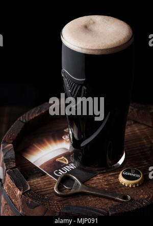 LONDON, Großbritannien - 03.Mai 2018: Original Glas Guinness Stout Bier auf Holzfass mit Flaschenöffner. Guinness Bier s erzeugt wurde. Stockfoto