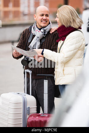 Reifen Ehegatten mit Gepäck und Karte auf Papier im Freien Stockfoto