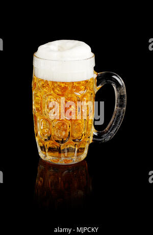 Bierkrug mit schäumendem Bier isoliert auf Schwarz. Stockfoto