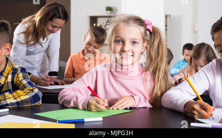Portrait von glücklichen Mädchen im Grundschulalter Zeichnung Klasse Stockfoto