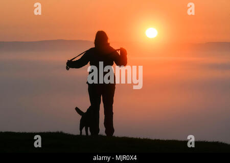 Glastonbury, Somerset, UK. 6. Mai 2018. UK Wetter. Besucher sehen den Sonnenaufgang, die über eine Schicht von Nebel steigt von der Spitze des Hügels an Glasonbury Tor in Somerset. Foto: Graham Jagd-/Alamy leben Nachrichten Stockfoto