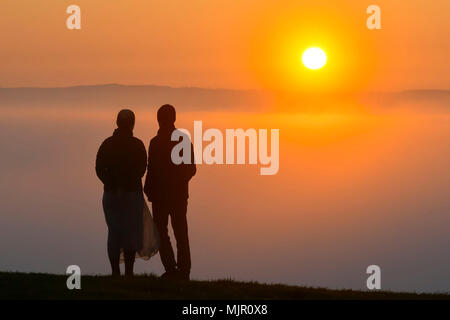 Glastonbury, Somerset, UK. 6. Mai 2018. UK Wetter. Besucher sehen den Sonnenaufgang, die über eine Schicht von Nebel steigt von der Spitze des Hügels an Glasonbury Tor in Somerset. Foto: Graham Jagd-/Alamy leben Nachrichten Stockfoto