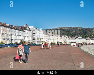 6. Mai 2018: Llandudno, North Wales - Leute auf Llandudno Promenade am frühen Morgen einen Spaziergang auf der sonnigen Tag Wochenende. Stockfoto