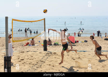 Boscombe, Bournemouth, Dorset, UK, 6. Mai 2018, Wetter: Morgen Sonnenschein an der Südküste auf, was die heißesten Mayday Bank Holiday Wochenende festgehalten werden könnte. Junge Männer spielen Beachvolleyball in der perfekte Bedingungen. Stockfoto