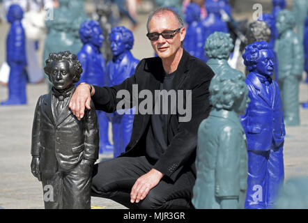 Ulm, Deutschland, 6. Mai 2018. Künstler Ottmar Hoerl kniend neben einer seiner kleinen Statuen von Albert Einstein am Münsterplatz. Die 500, ca. 1 Meter hohen Einstein Statuen auf Münsterplatz für mehrere Wochen zu bleiben. Foto: Stefan Puchner/dpa Quelle: dpa Picture alliance/Alamy leben Nachrichten Stockfoto