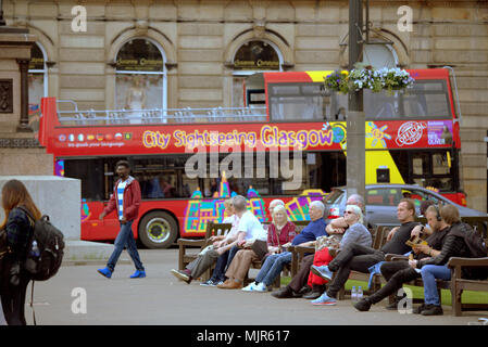 Glasgow, Schottland, Großbritannien 6. Mai. UK Wetter: Stadtbesichtigung Glasgow bus Menschen auf Bänken sonnigen Sommer Wetter schließlich die Stadt für die Bank Holiday Wochenende erreicht. Einheimische und Touristen genießen die Sonne in den George Square die bürgerliche Herz der Stadt. Gerard Fähre / alamy Nachrichten Stockfoto