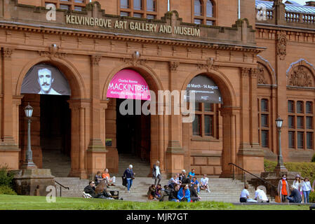 Glasgow, Schottland, Großbritannien 6. Mai. UK Wetter: Sonnig Sommer Wetter schließlich erreicht die Stadt für das Wochenende. Einheimische und Touristen genießen die Sonne außerhalb der Kelvingrove Kunstgalerie und Museum zeigt Charles Rennie Mackintosh Ausstellung in der Plüsch West End der Stadt. Gerard Fähre / alamy Nachrichten Stockfoto