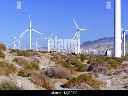 Windkraftanlagen erzeugen erneuerbare Energie auf Windparks in Wüste mit Bergen im Hintergrund, eine Technologie, die Abkehr von fossilen Brennstoffen zu bewegen Stockfoto