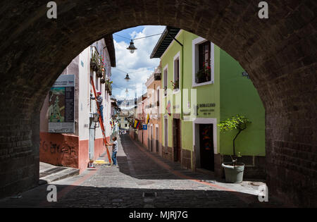 QUITO, ECUADOR - Oktober 27, 2015: Arbeitnehmer fix ein Fenster in der Calle La Ronda, typische und bunten kolonialen Street im historischen Stadtteil, durch t gesehen Stockfoto