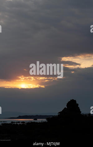 Sun späht aus dem Morgen Wolken über tuffstein Silhouetten am Mono Lake bei Sonnenaufgang. Stockfoto