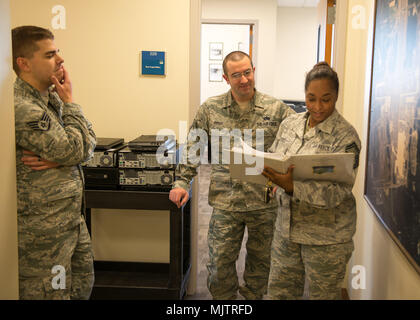 Staff Sgt. Michael Servis und Technischen Sgt. Andrew Perry der 102 Intelligenz Flügel Communications Flug unterstützen Senior Master Sgt. Andrea Burgo installieren Sie neue Computer in der Befehl Gebäude am Otis Air National Guard Base, Joint Base Cape Cod, Massachusetts. Stockfoto