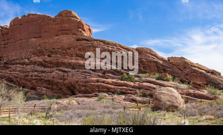 Felsformation unter einem blauen Himmel mit einem partiellen Holzzaun Linie im Vordergrund Red Rocks Amphitheater, Colorado USA Stockfoto