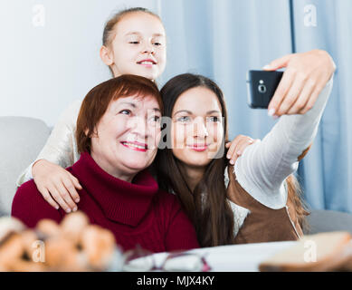 Lächelnde Frau, die selfie mit Mutter und Tochter zu Hause Stockfoto