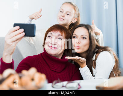 Gerne ältere Frau unter selfie mit ihrer erwachsenen Tochter und Enkelin zu Hause Stockfoto