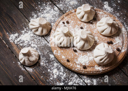 Stapel der hausgemachten raw khinkali Knödel schließen bis auf das Holz rustikale Tabelle Stockfoto