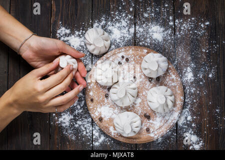 Nationale georgische Küche Khinkali. Frau bereitet khinkali. Ansicht von oben rohes Fleisch Teig Teller ungekocht. Prozess kochen. Stockfoto