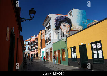 Menschen zu Fuß auf der Calle Mequinez, Puerto de la Cruz, Teneriffa in einem hellen und warmen November Tag; bunte Häuser in La Ranilla Bezirk. Stockfoto