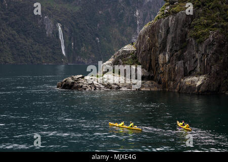 MILFORD SOUND, Neuseeland - 14. NOVEMBER 2017: Kajakfahrer die Landschaft und die Wasserfälle von Milford Sound, eine der populärsten Touristenattraktionen in Neuseeland genießen Stockfoto