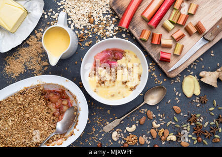 Hausgemachte gewürzt Rhabarber crumble und Vanillepudding. Großbritannien Stockfoto