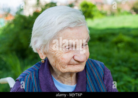 Close up Portrait von lächelnden älteren Frau an Demenz leiden Krankheit, outdoor Stockfoto