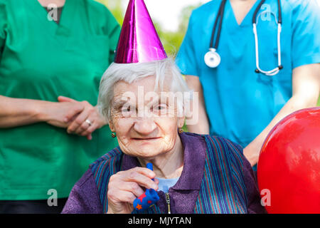 Close up Portrait von älteren behinderten Frau feiert Geburtstag mit medizinische Hilfe Stockfoto