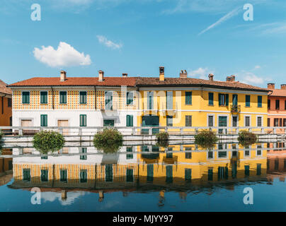 Stadtbild von Gaggiano, nur außerhalb von Mailand. Bunte Häuser im Kanal Naviglio Grande Wasserstraße widerspiegelt Stockfoto