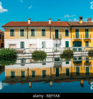 Stadtbild von Gaggiano, nur außerhalb von Mailand. Bunte Häuser im Kanal Naviglio Grande Wasserstraße widerspiegelt Stockfoto