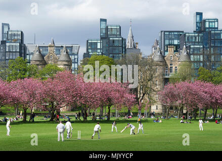 Eine Grille übereinstimmen, die in den Wiesen, Edinburgh mit den Wohnungen in der quartermile in der Ferne. Stockfoto