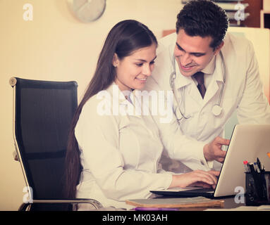 Lächelnd intern fragen Beratung von medizinischen Betreuer an der Klinik der Rezeption. Fokus auf Frau Stockfoto