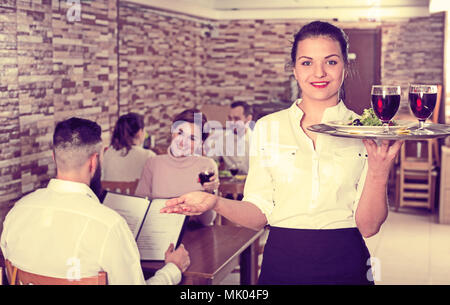 Lächelnden jungen Frau Kellner zeigen Land Restaurant Besucher Stockfoto