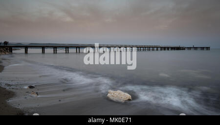 Marine mit Steg in einer dramatischen bewölkter Sonnenuntergang in die Stadt Polis, in Paphos, Zypern Stockfoto