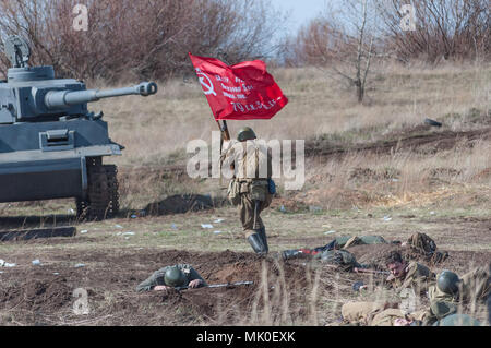 2018-04-30 Die Samara, Russland. Soldaten der Sowjetischen Armee mit der Fahne in die Offensive. Wiederaufbau der Kampfhandlungen im April 1945. Stockfoto
