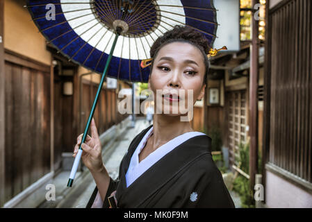 Japanische Frau, die traditionelle Kleidung und Walking im Freien Stockfoto