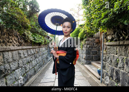 Japanische Frau, die traditionelle Kleidung und Walking im Freien Stockfoto