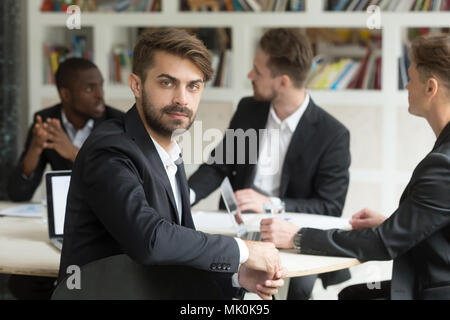 Männliche Arbeiter bei Kamera bei Firma business meeting suchen Stockfoto