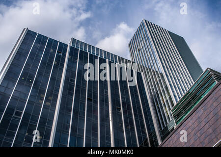 Ansicht von unten auf die Fassaden der modernen Bürohochhäuser gegen den blauen Himmel. Low Angle Shot. Stockfoto