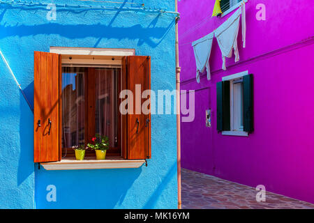 Wände in kräftigen Farben mit Fenstern und Fensterläden aus Holz in Burano, Italien gemalt. Stockfoto