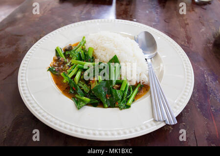 Reis mit gesalzenem Fisch Grünkohl in weiße Scheibe in Thai Restaurant Stockfoto