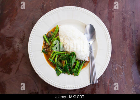 Reis mit gesalzenem Fisch Grünkohl in weiße Scheibe in Thai Restaurant Stockfoto