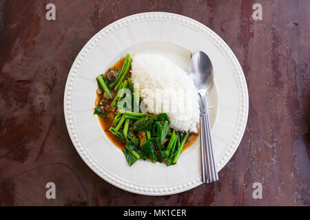 Reis mit gesalzenem Fisch Grünkohl in weiße Scheibe in Thai Restaurant Stockfoto