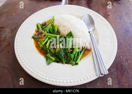 Reis mit gesalzenem Fisch Grünkohl in weiße Scheibe in Thai Restaurant Stockfoto