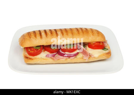 Käse, Tomaten, Schinken, Zwiebeln und Basilikum Panini auf einer Platte gegen Weiße isoliert Stockfoto