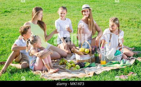 Portrait von froh, dass Frauen mit glücklichen Kindern im Sommer Picknick im Park Stockfoto