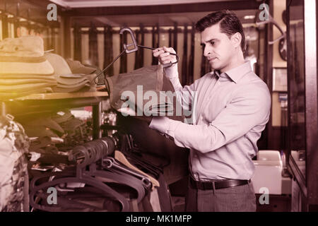 Stattlichen erwachsenen männlichen Jäger Auswahl Jagd in Store Stockfoto