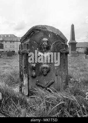 GLASGOW, Schottland - 23. APRIL 2018: ein schwarz-weiß Foto eines Engels, ein Schädel und Knochen Kreuz auf einem grabstein an der Govan alte Pfarrkirche. Stockfoto