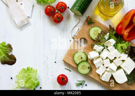 Feta Käse und schwarzen Oliven, Kochen qreek Salat mit frischem Gemüse auf einem weißen Holztisch. Stockfoto