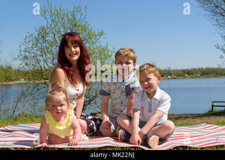 Mutter mit zwei Söhne und Tochter von einem am See an einem sonnigen Nachmittag Stockfoto