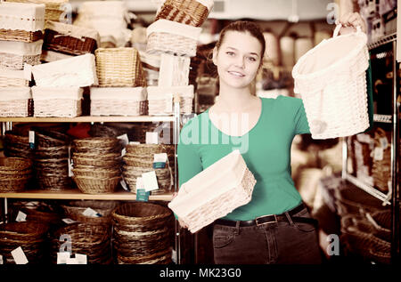 Junges Mädchen zeigt, Weidenkörbe in einem Dekor shop Stockfoto