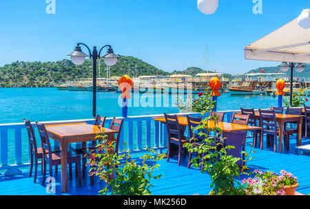 Die hellen blauen Holzterrasse von Café im Freien mit Blick auf die Yachten und Boote im Hafen von Üçagiz, Kekova, Türkei. Stockfoto